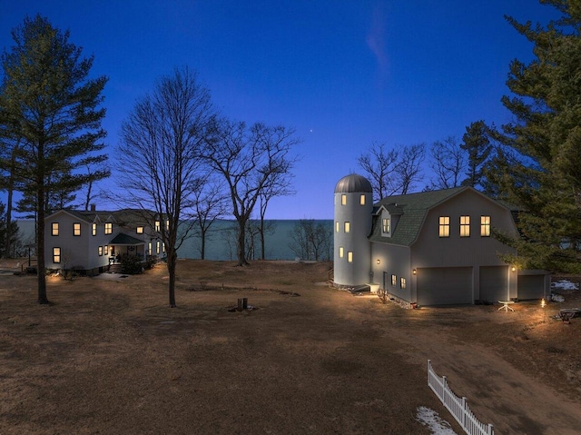 8282 W Harrison Rd, Mears, MI 49436 - view of front of house with a gambrel roof, dirt driveway, and an attached garage