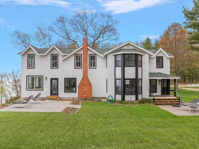 8282 W Harrison Rd, Mears, MI 49436 - back of property with a chimney, a patio, a lawn, and a shingled roof