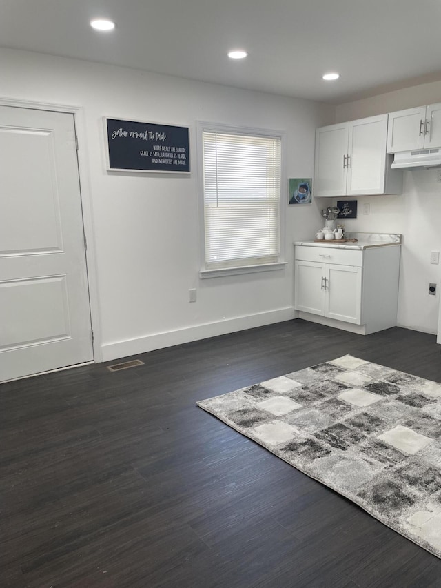8841 Auburn St, Detroit, MI 48228 - kitchen featuring white cabinets, under cabinet range hood, dark wood-type flooring, recessed lighting, and baseboards