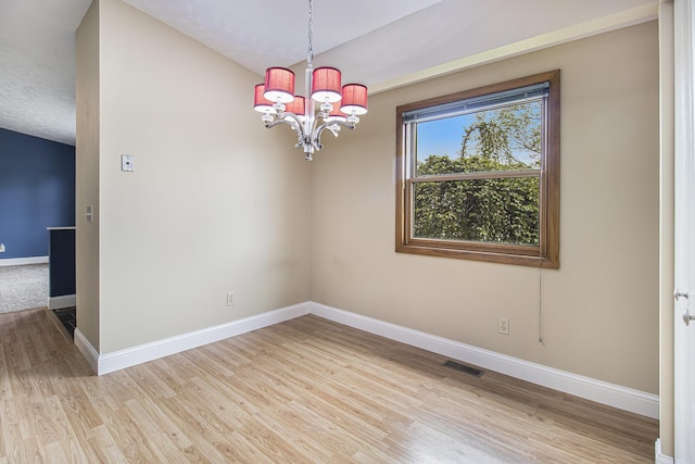 6001 Dover Ln, Michigan, MI 49684 - unfurnished room featuring baseboards, wood finished floors, a chandelier, and vaulted ceiling