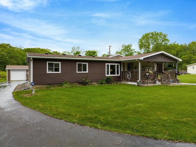 4200 Chapman Rd, Stockbridge, MI 49285 - ranch-style house featuring covered porch, an outbuilding, a front yard, and a garage