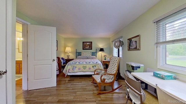 4200 Chapman Rd, Stockbridge, MI 49285 - bedroom featuring wood finished floors, multiple windows, and a desk