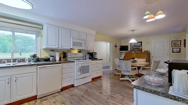 4200 Chapman Rd, Stockbridge, MI 49285 - kitchen featuring white appliances, a sink, dark countertops, white cabinets, and hanging light fixtures