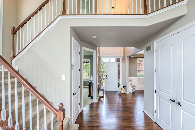 58799 Carriage Ln, South Lyon, MI 48178 - foyer featuring stairway, dark wood finished floors, a wainscoted wall, and a decorative wall