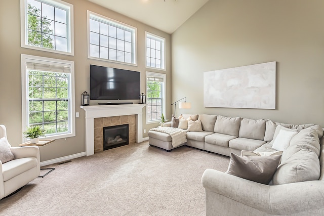58799 Carriage Ln, South Lyon, MI 48178 - carpeted living area with high vaulted ceiling, baseboards, a fireplace, and plenty of natural light