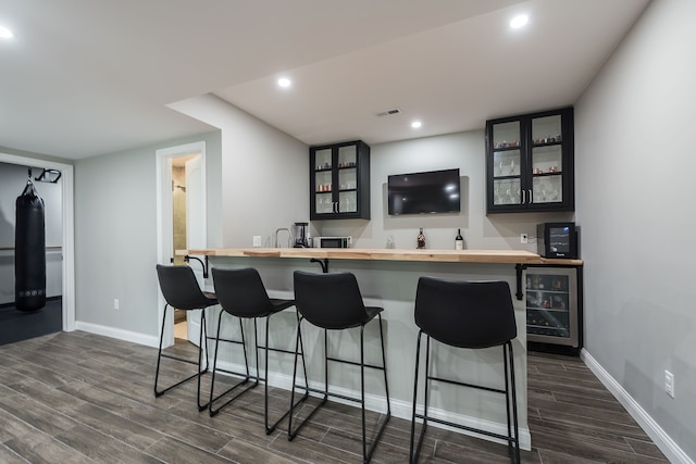 58799 Carriage Ln, South Lyon, MI 48178 - indoor wet bar with dark wood-style floors, baseboards, beverage cooler, and recessed lighting