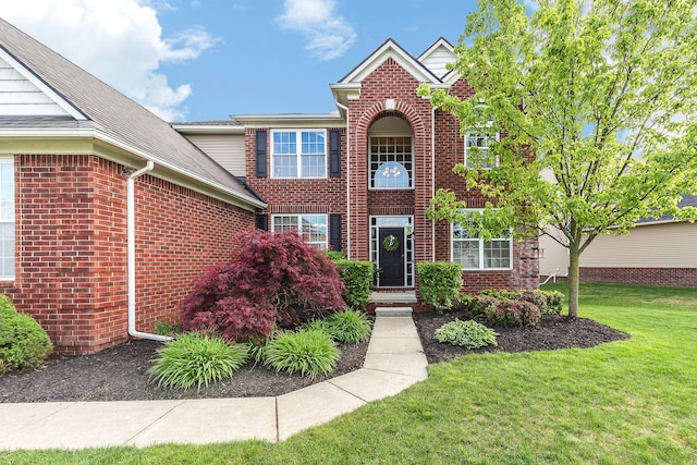 58799 Carriage Ln, South Lyon, MI 48178 - traditional-style home featuring brick siding, a front lawn, and roof with shingles