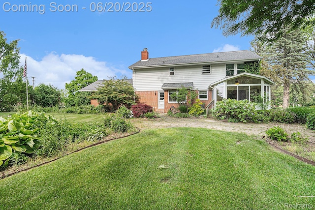 8276 Appleway Dr, Grand Blanc, MI 48439 - back of house with brick siding, a sunroom, a chimney, and a yard