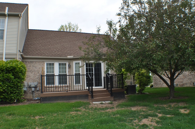 4439 Hunters Cir W, Canton, MI 48188 - rear view of house with a lawn, a shingled roof, brick siding, a deck, and central AC