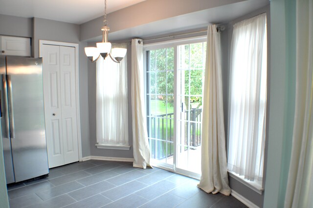 4439 Hunters Cir W, Canton, MI 48188 - unfurnished dining area featuring a chandelier, dark tile patterned flooring, and baseboards