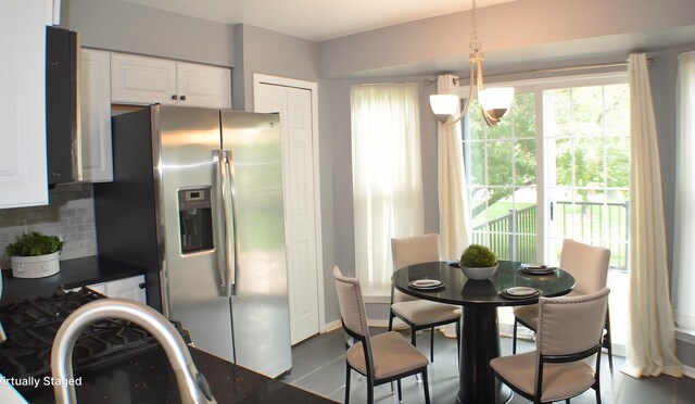 4439 Hunters Cir W, Canton, MI 48188 - kitchen with stainless steel refrigerator with ice dispenser, backsplash, white cabinetry, hanging light fixtures, and dark countertops