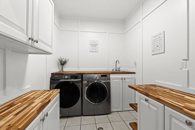 9997 Applegate Ln, Brighton, MI 48114 - laundry area with washing machine and dryer, light tile patterned floors, and cabinet space