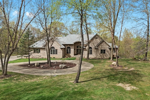 9997 Applegate Ln, Brighton, MI 48114 - french country home featuring a front lawn and brick siding