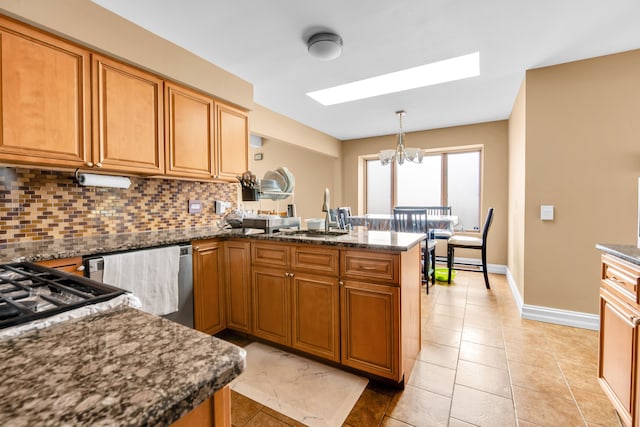 38342 Sleigh Dr, Sterling Heights, MI 48310 - kitchen with a sink, a peninsula, decorative backsplash, a skylight, and a chandelier