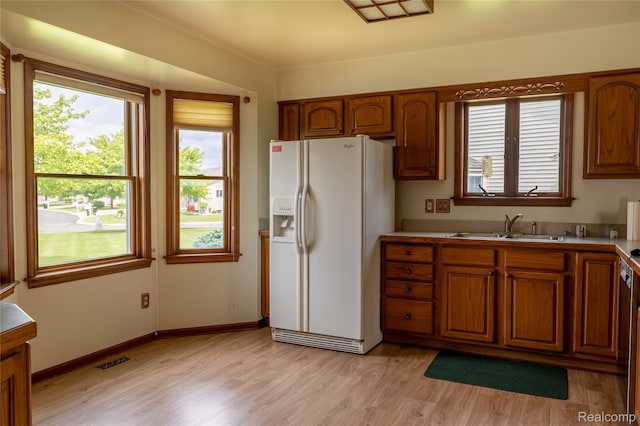 4359 Springbrook Dr, Swartz Creek, MI 48473 - kitchen featuring white refrigerator with ice dispenser, a sink, brown cabinetry, and light wood-type flooring