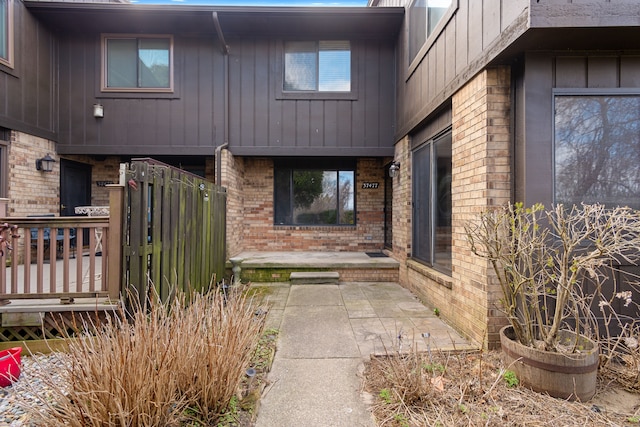 entrance to property featuring brick siding and board and batten siding