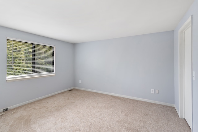 carpeted empty room with baseboards