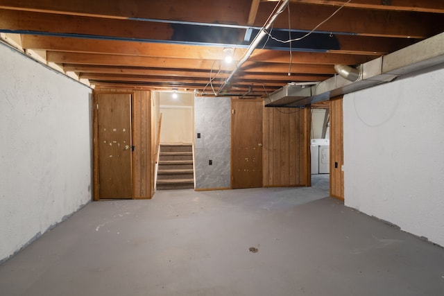 unfinished basement with stairway and washing machine and clothes dryer