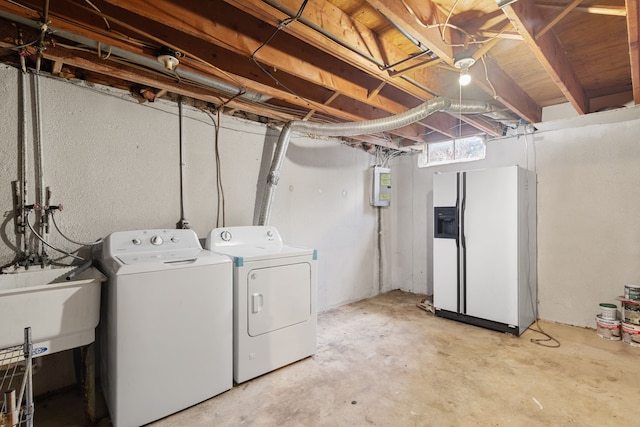 basement with white refrigerator with ice dispenser, separate washer and dryer, electric panel, and a sink