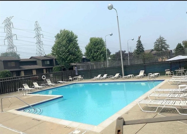 community pool featuring fence and a patio area