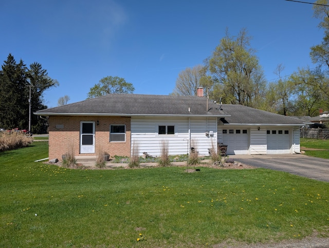 rear view of house featuring driveway, a lawn, an attached garage, brick siding, and a chimney