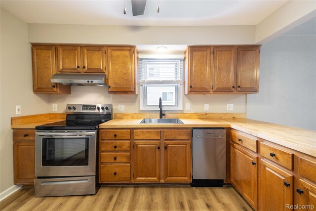1953 Elmhurst St, Canton, MI 48187 - kitchen featuring appliances with stainless steel finishes, ventilation hood, a sink, and brown cabinetry