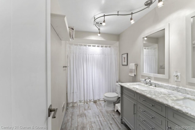 26155 Timber Trl, Dearborn Heights, MI 48127 - bathroom with double vanity, toilet, a shower with curtain, and wood finished floors