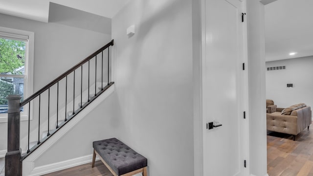 stairway with wood finished floors, recessed lighting, and baseboards