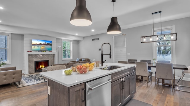 kitchen with dishwasher, a sink, dark wood-style flooring, light countertops, and recessed lighting