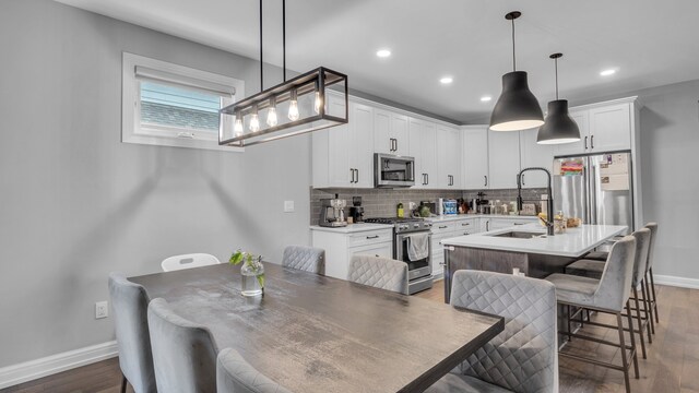 dining space with baseboards, wood finished floors, and recessed lighting