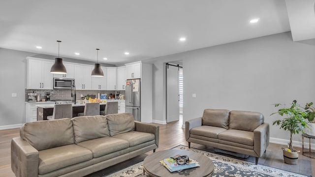 living room with light wood finished floors, baseboards, and recessed lighting