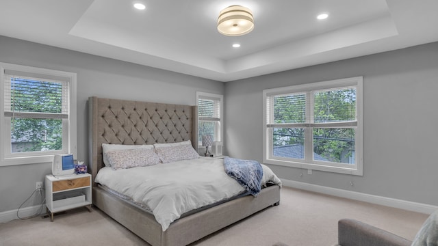 carpeted bedroom with a raised ceiling, baseboards, and recessed lighting