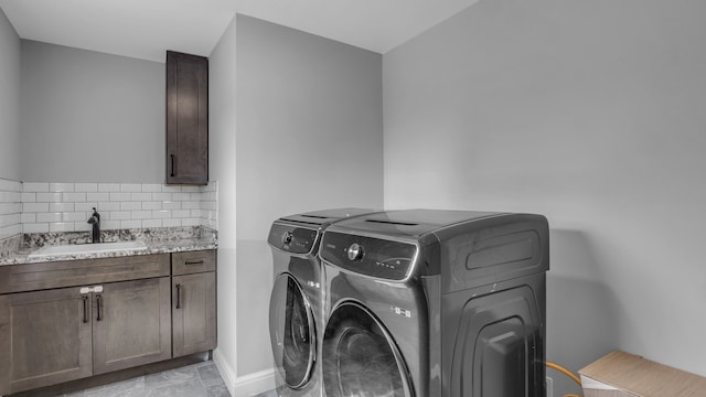 laundry room featuring separate washer and dryer, cabinet space, and baseboards