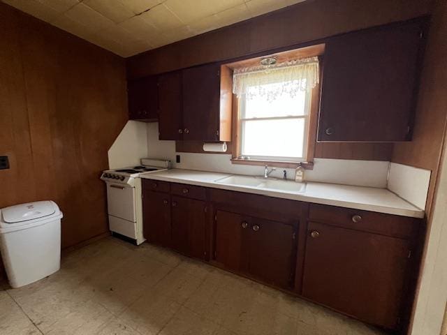 205 Evans St, East Tawas, MI 48730 - kitchen featuring white electric range, a sink, light countertops, and dark brown cabinets