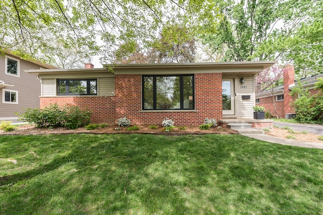 2441 Nottingham Rd, Ann Arbor, MI 48104 - view of front of house featuring brick siding, a front lawn, and a chimney