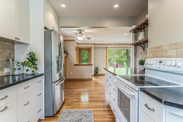 2441 Nottingham Rd, Ann Arbor, MI 48104 - kitchen featuring electric range, stainless steel refrigerator with ice dispenser, backsplash, dark countertops, and white cabinetry
