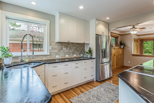 2441 Nottingham Rd, Ann Arbor, MI 48104 - kitchen featuring stainless steel fridge, light wood-style floors, a sink, white cabinetry, and recessed lighting