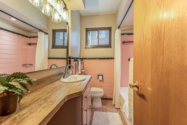 2441 Nottingham Rd, Ann Arbor, MI 48104 - bathroom with tile walls, toilet, vanity, and shower / tub combo