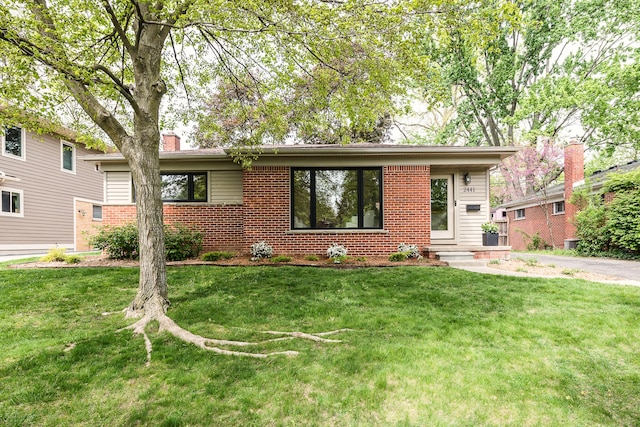 2441 Nottingham Rd, Ann Arbor, MI 48104 - view of front of property featuring a chimney, a front yard, and brick siding