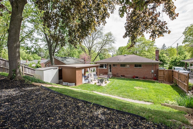 2441 Nottingham Rd, Ann Arbor, MI 48104 - back of property featuring brick siding, a patio, a chimney, and an outdoor fire pit