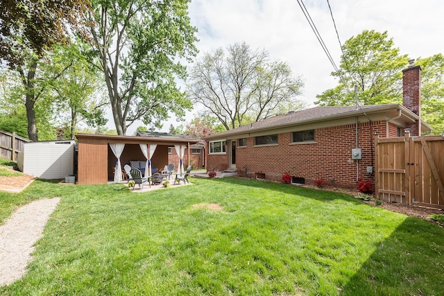 2441 Nottingham Rd, Ann Arbor, MI 48104 - back of property with a chimney, a fire pit, brick siding, a patio area, and a gate