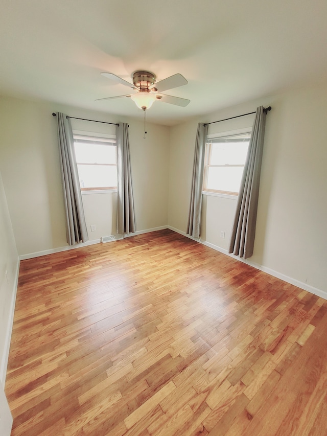 1082 Morris Rd, Lapeer, MI 48446 - empty room featuring plenty of natural light, light wood finished floors, a ceiling fan, and baseboards