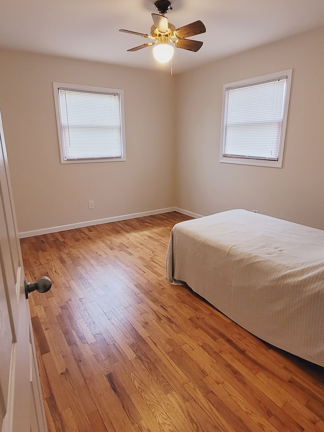 1082 Morris Rd, Lapeer, MI 48446 - bedroom featuring multiple windows, wood finished floors, and baseboards