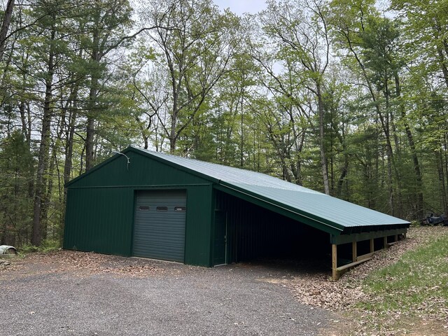 8711 M-37, Irons, MI 49644 - garage with a garage and a forest view