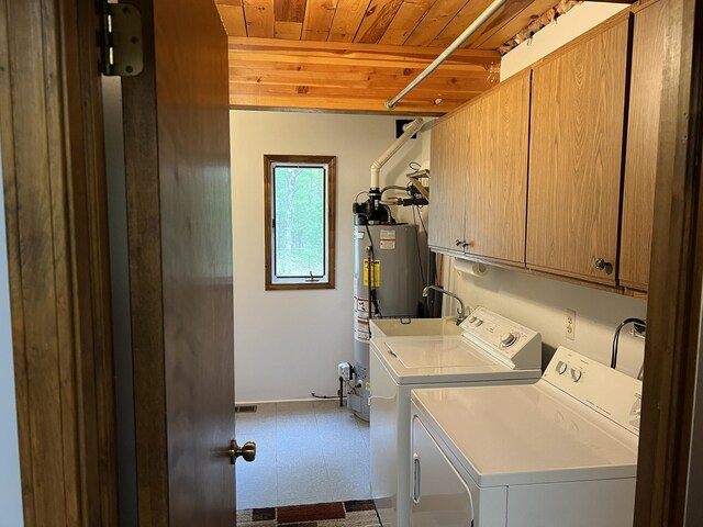8711 M-37, Irons, MI 49644 - washroom with washing machine and dryer, wooden ceiling, cabinet space, tile patterned floors, and gas water heater