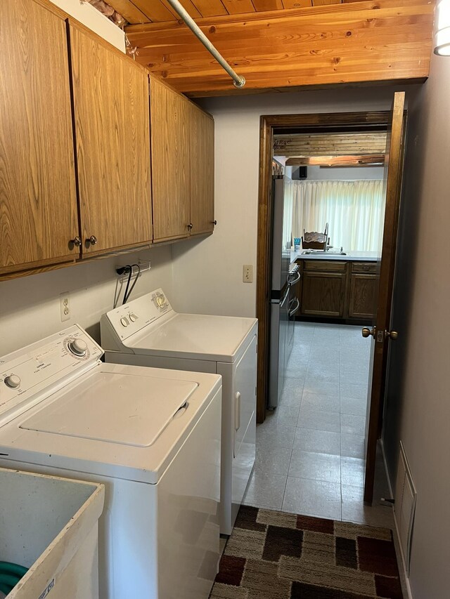 8711 M-37, Irons, MI 49644 - laundry area with cabinet space, washer and dryer, and light tile patterned flooring