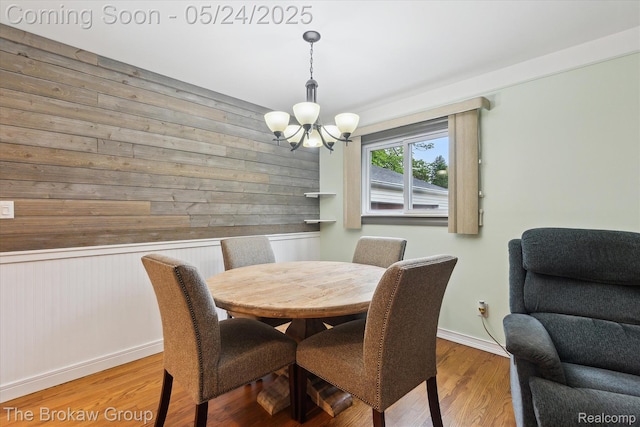 6605 Northview Dr, Clarkston, MI 48346 - dining space with a chandelier, wooden walls, wood finished floors, and baseboards