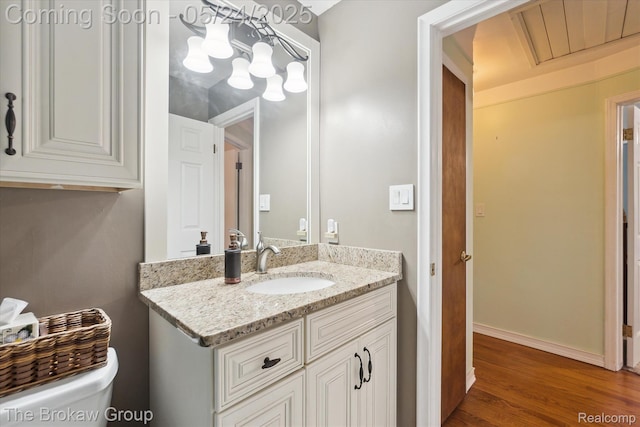 6605 Northview Dr, Clarkston, MI 48346 - half bathroom featuring vanity, toilet, wood finished floors, and baseboards