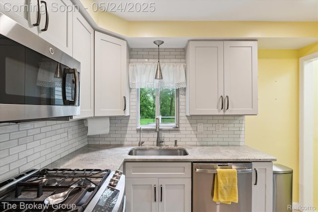 6605 Northview Dr, Clarkston, MI 48346 - kitchen with appliances with stainless steel finishes, a sink, decorative backsplash, and light stone counters