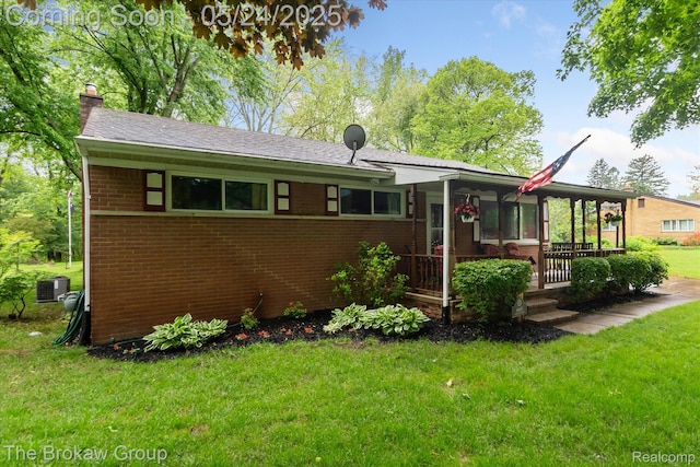 6605 Northview Dr, Clarkston, MI 48346 - view of front of house with a chimney, brick siding, a front yard, and central air condition unit
